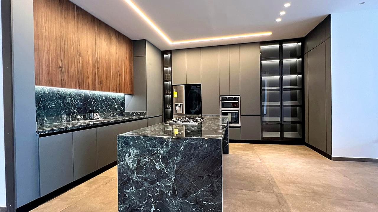 Integrated kitchen with stone island and grey cabinetry